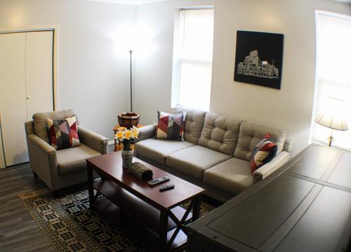 2 Bedroom East Carson Street Sanctuary في بيتسبرغ: غرفة معيشة مع أريكة وطاولة قهوة