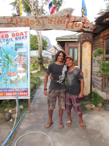 a man and a woman standing next to a sign at PP Red Tuna Hut in Phi Phi Don