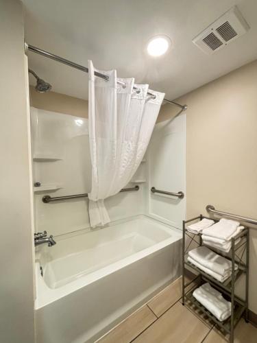 a white bathroom with a tub and a shower at Baymont by Wyndham Lake Park Valdosta I75 in Lake Park