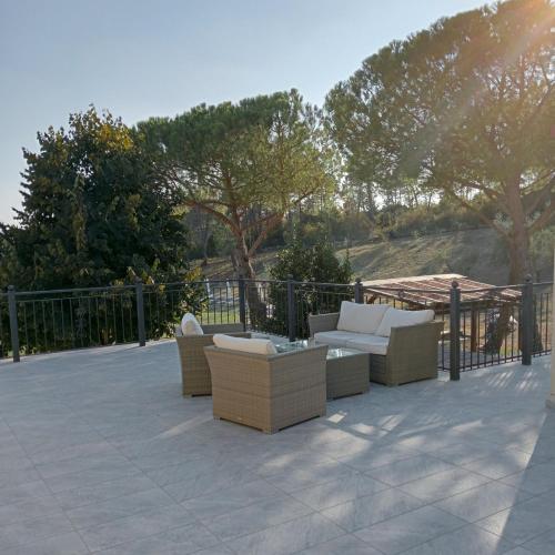 een patio met banken en tafels en een hek bij Casa di Palaia in Strada