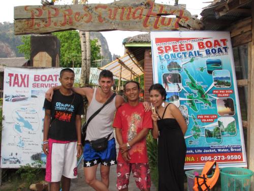 a group of people standing in front of a sign at PP Red Tuna Hut in Phi Phi Don