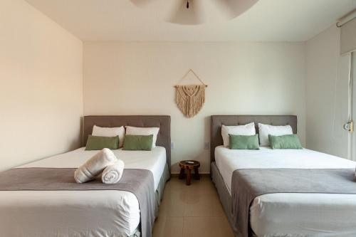 two beds sitting next to each other in a room at Via Tendenza Condos in Playa del Carmen