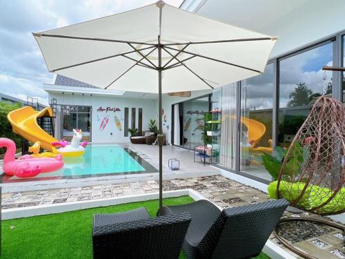 a backyard with a pool and an umbrella at Anya Pool Villa Pattaya in Ban Huai Yai