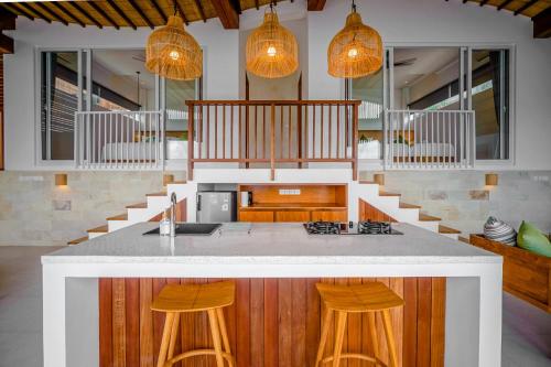 an open kitchen with a counter and some lights at The Angsa villas in Amed