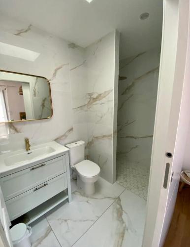 une salle de bain blanche avec un lavabo et des toilettes dans l'établissement Sunset House, à Mimizan