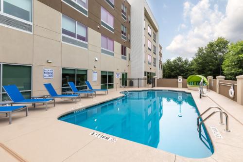 una piscina con sedie e un edificio di Holiday Inn Express & Suites - Rock Hill, an IHG Hotel a Rock Hill
