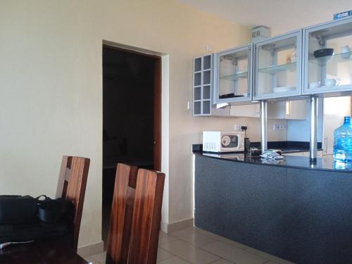 a kitchen with a black counter and a microwave at Lagos Diani in Diani Beach