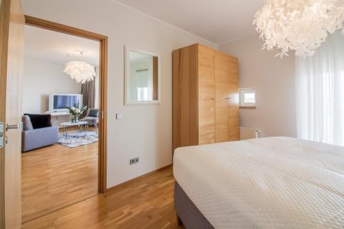 a bedroom with a bed and a mirror and a living room at City Center Luxury Apartment in Tartu