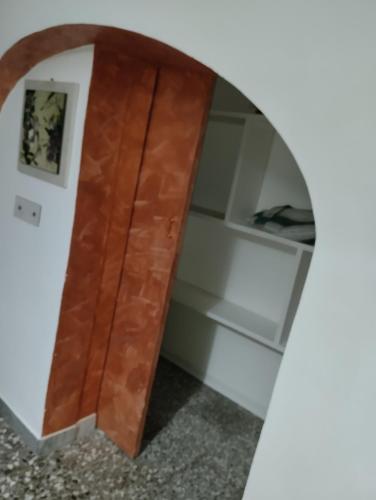 a wooden door in a room with a shelf at L' Archè in Castellaneta