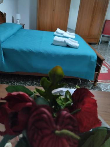a room with a bed and a plate of flowers on a table at L' Archè in Castellaneta