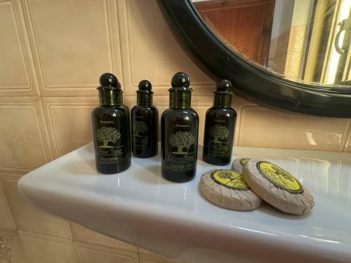 a group of four bottles on a bathroom sink at The 3 Little Pigs apartments in Sidari