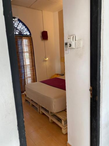 a small bedroom with a bed in a room at Seconds Hostel - Colombo in Colombo