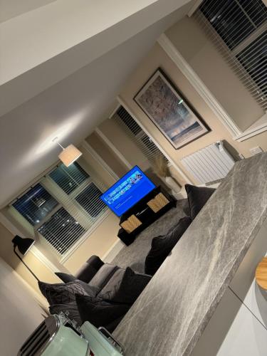 a living room with a couch and a television at Central 2 bedroom apartment in Wick