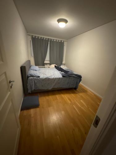 a bedroom with a bed and a wooden floor at Nice room in Borås