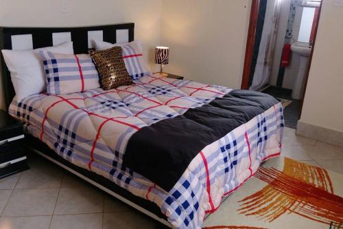 een slaapkamer met een groot bed in een kamer bij Fully furnished 3br, master ensuite penthouse. in Ruaka