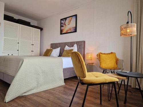 een slaapkamer met een bed en een tafel en stoelen bij Studio Noordzee in Egmond aan Zee