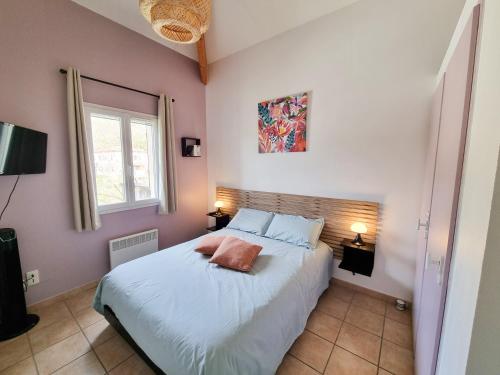 een slaapkamer met een bed met witte lakens en roze muren bij Les Hauts de Sarlat G4 - Clim Piscine Parking WiFi in Sarlat-la-Canéda
