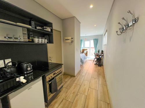 a kitchen with a stove and a wooden floor at Entire Studio Apartment in Maboneng in Johannesburg