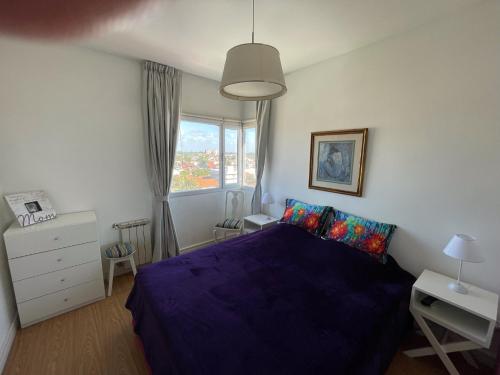マル・デル・プラタにあるFrenteMarの紫色のベッドと窓のある寝室