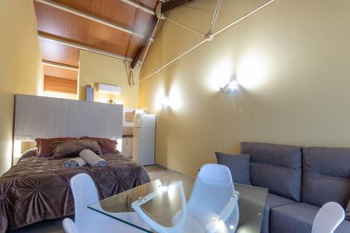 uma sala de estar com uma cama e um sofá em Apartamentos Basílica Santa Eulalia PARKING INCLUIDO em Mérida