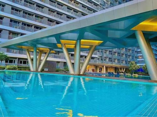ein großer Pool vor einem großen Gebäude in der Unterkunft 1BR w/ Balcony near Megamall: The Admiral‘s Lounge in Manila