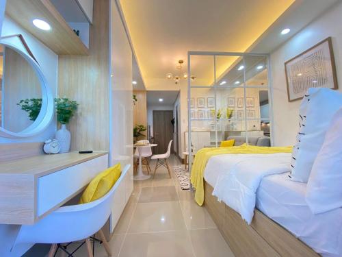 Schlafzimmer mit einem Bett mit einem Spiegel und einem Tisch in der Unterkunft 1BR w/ Balcony near Megamall: The Admiral‘s Lounge in Manila