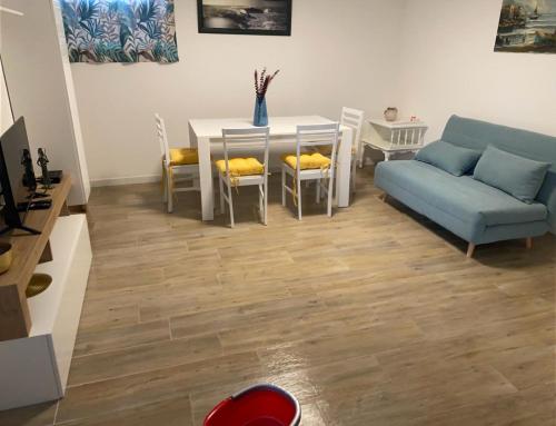 a living room with a table and a blue couch at Casa Sofia - Appartamento ristrutturato a Castiglione della Pescaia, località Rocchette in Castiglione della Pescaia
