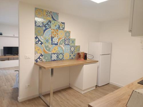 a kitchen with a table and a refrigerator at Casa Sofia - Appartamento ristrutturato a Castiglione della Pescaia, località Rocchette in Castiglione della Pescaia