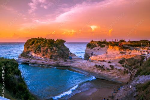a group of people on a beach at sunset at The 3 Little Pigs apartments in Sidari