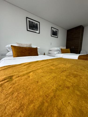 Una cama o camas en una habitación de Hotel WLH Gold Bogota