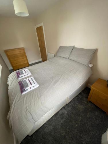 a bedroom with a large bed with a night stand at Central 2BR Apartment - Sleeps 4 - Parking & Pets - Coast Serviced Apartments - Enquire for Trade & Long stays in Wick