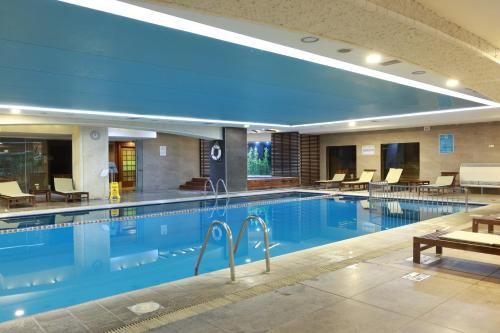 - une piscine dans un hôtel avec des chaises et des tables dans l'établissement Anemon Cigli Hotel, à Izmir