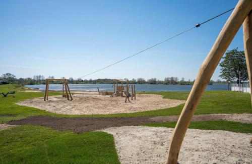 a park with a playground with a swing at Luxe chalet in prachtig natuurgebied in Lith