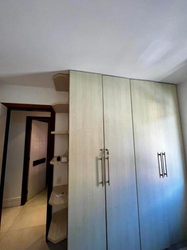 a large white cabinet in a room with a hallway at Seu cantinho no paraíso de Guarajuba - Bahia in Guarajuba
