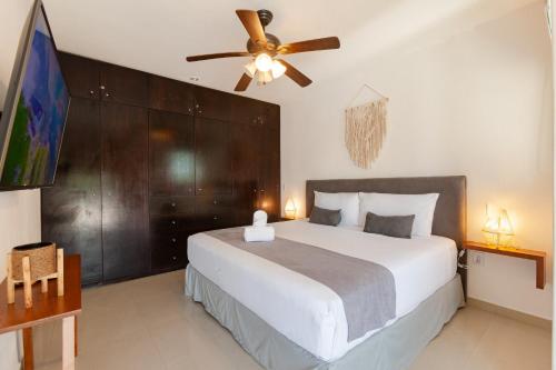 a bedroom with a large bed and a ceiling fan at Via Tendenza Condos in Playa del Carmen