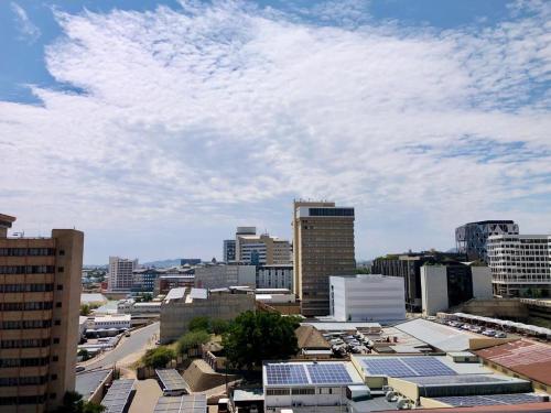 a city skyline with many buildings and solar panels at Cosy Apartment In The Heat Of The City in Windhoek