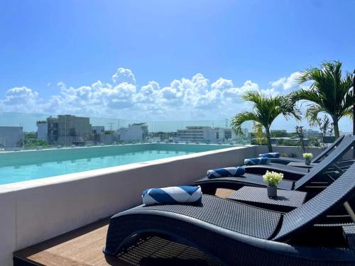 a balcony with lounge chairs and a swimming pool at Suite de lujo 1 Hab. Depto 203 in Playa del Carmen