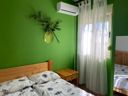 a bedroom with a bed and a green wall at Delight Apartments in Golem