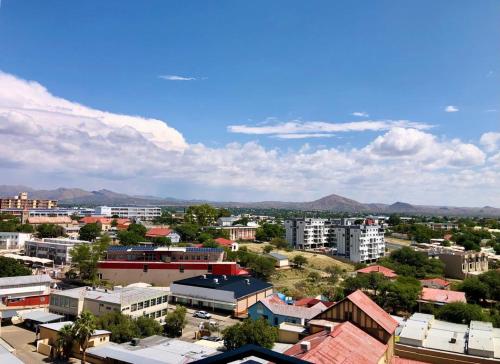 an aerial view of a city with buildings and mountains at Cosy Apartment In The Heat Of The City in Windhoek