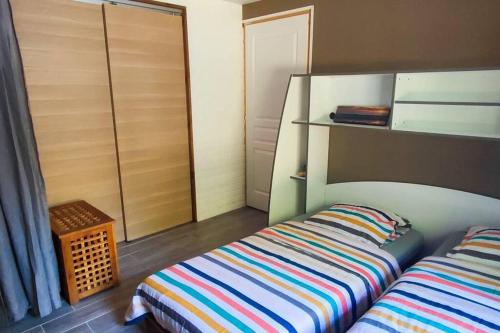 - une chambre avec un lit rayé et un placard dans l'établissement Villa de vacances, à Grayan-et-lʼHôpital