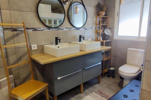 La salle de bains est pourvue de 2 lavabos, d'un miroir et de toilettes. dans l'établissement Villa de vacances, à Grayan-et-lʼHôpital