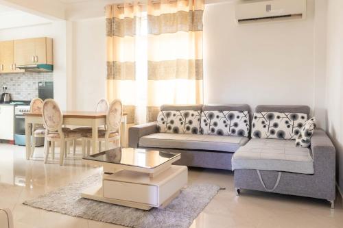 - un salon avec un canapé et une table dans l'établissement Sir Edwards two bedroom Inn at Masaki, à Dar es Salaam