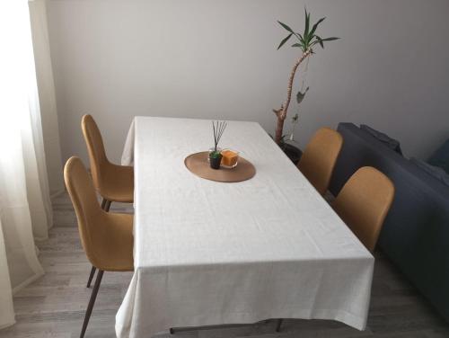 einen Esstisch mit einem weißen Tischtuch drauf in der Unterkunft Vaidaugu Cosy Apartment, Klaipeda in Klaipėda
