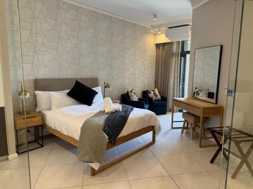 um quarto com uma cama e uma secretária num quarto em Menlyn Maine Triology - 10 On Capital em Pretoria