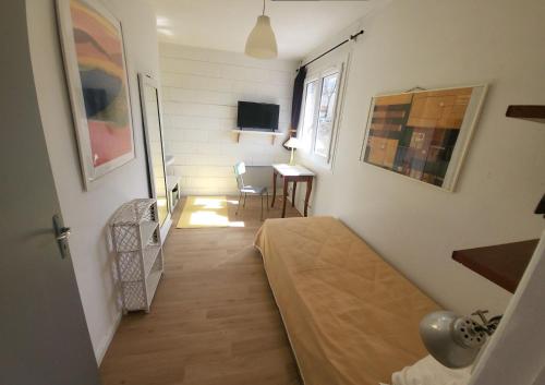 een kamer met een bed, een tafel en een raam bij Le Jardin De Nicolas in Couret