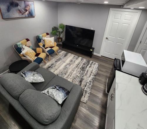 Una sala de estar con un sofá y un televisor de pantalla plana. en Entire Basement Suite with Private Entrance, en Winnipeg