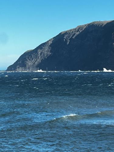 a large body of water with a mountain in the background at L’Asile de l’Anse-Pleureuse in Mont-Louis