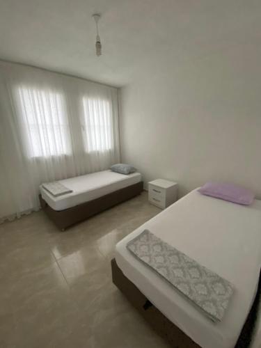 a bedroom with two beds and a window at Kiralık Yazlık in Kuşadası
