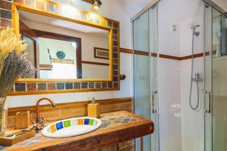 a bathroom with a sink and a shower with a mirror at Casa Golf Azul - Suite Viagens in Aljaraque
