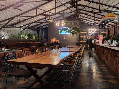 a restaurant with a large wooden table and chairs at Astra Hotels & Suites - Kadubeesanahalli ,Opposite Oracle and JP Morgan, Marathahalli Outer Ring Road in Bengaluru